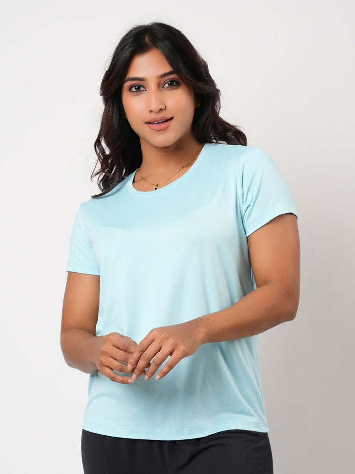 Woman wearing a light blue t-shirt against a plain background