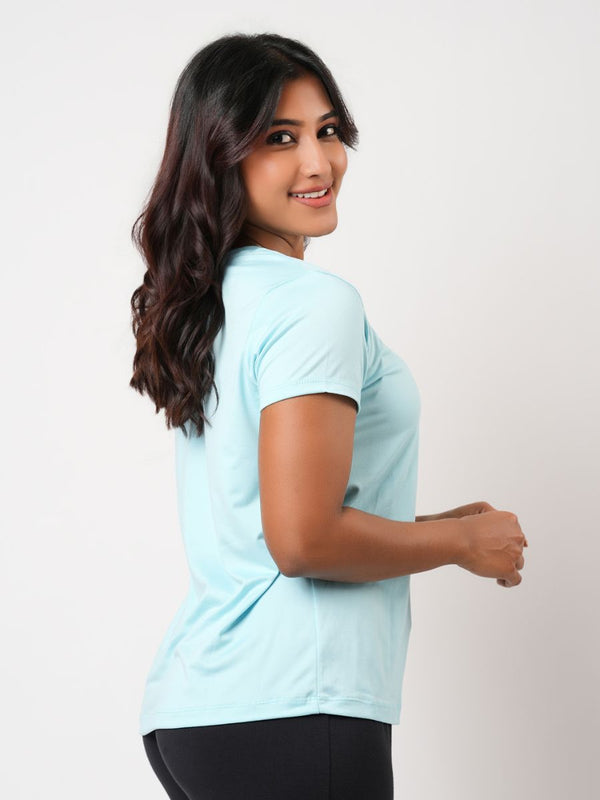Woman wearing a light blue t-shirt on a plain background
