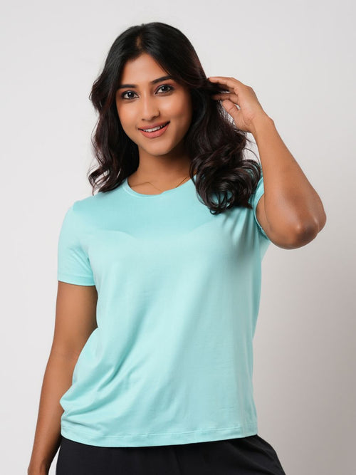 Woman wearing a light blue t-shirt against a plain background