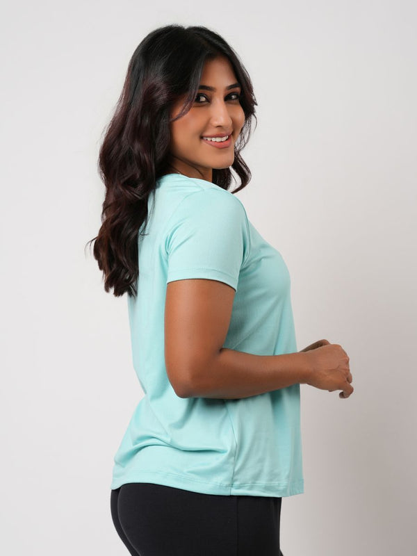 Woman wearing a light blue t-shirt against a plain background