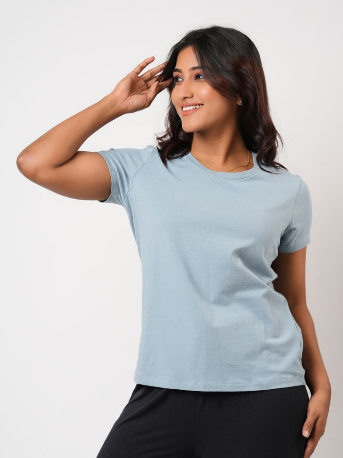 Woman wearing a light blue t-shirt against a plain background
