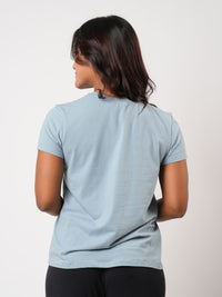 Person wearing a light blue t-shirt on a plain background
