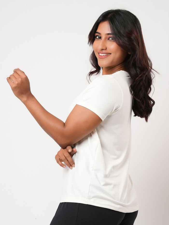 Woman wearing a white t-shirt against a plain background