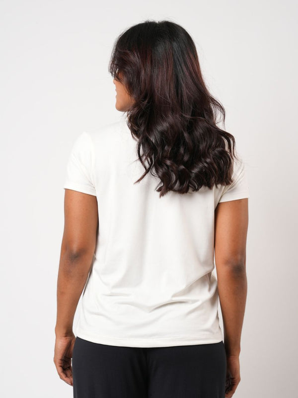 Person wearing a plain white t-shirt against a light background