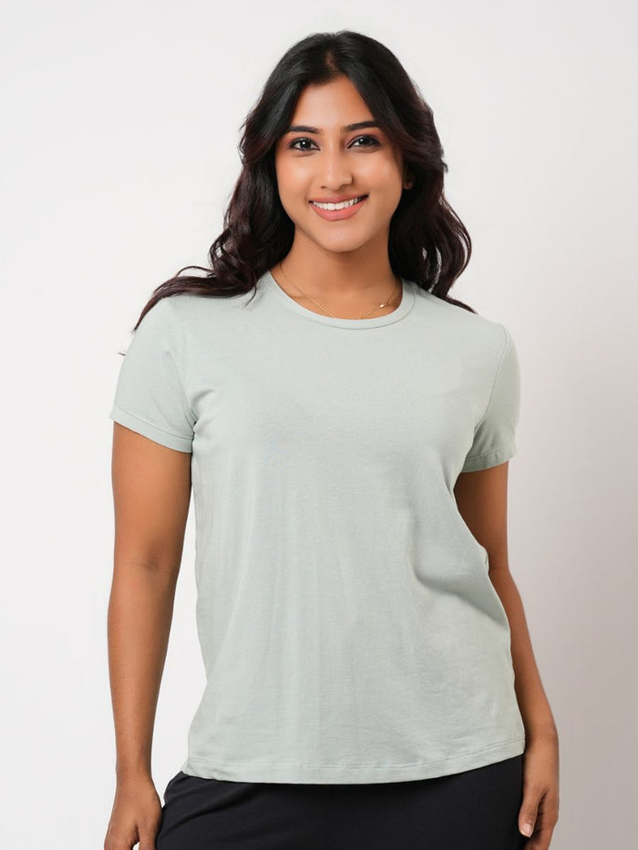 Woman wearing a light green t-shirt against a plain background
