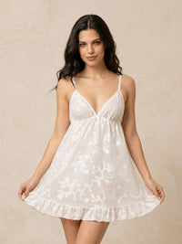 Woman wearing a white lace nightgown against a beige background