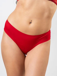 Red bikini bottom worn by a person on a white background
