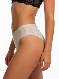 Person wearing beige patterned underwear on a white background